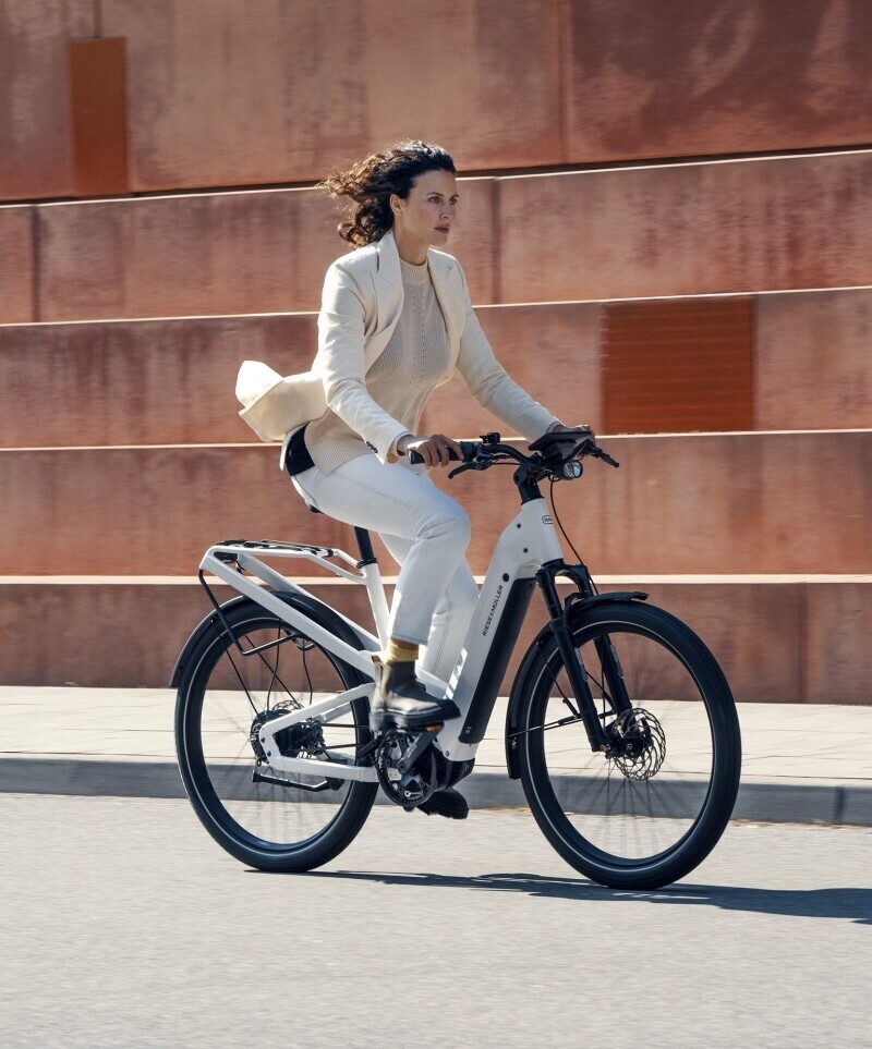 Vrouw op een witte speed pedelec die ze kan leasen via het werk